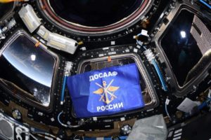 фотография с флагом ДОСААФ с орбиты МКС